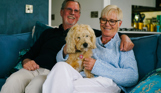 Stables Owners smiling with dog on sofa