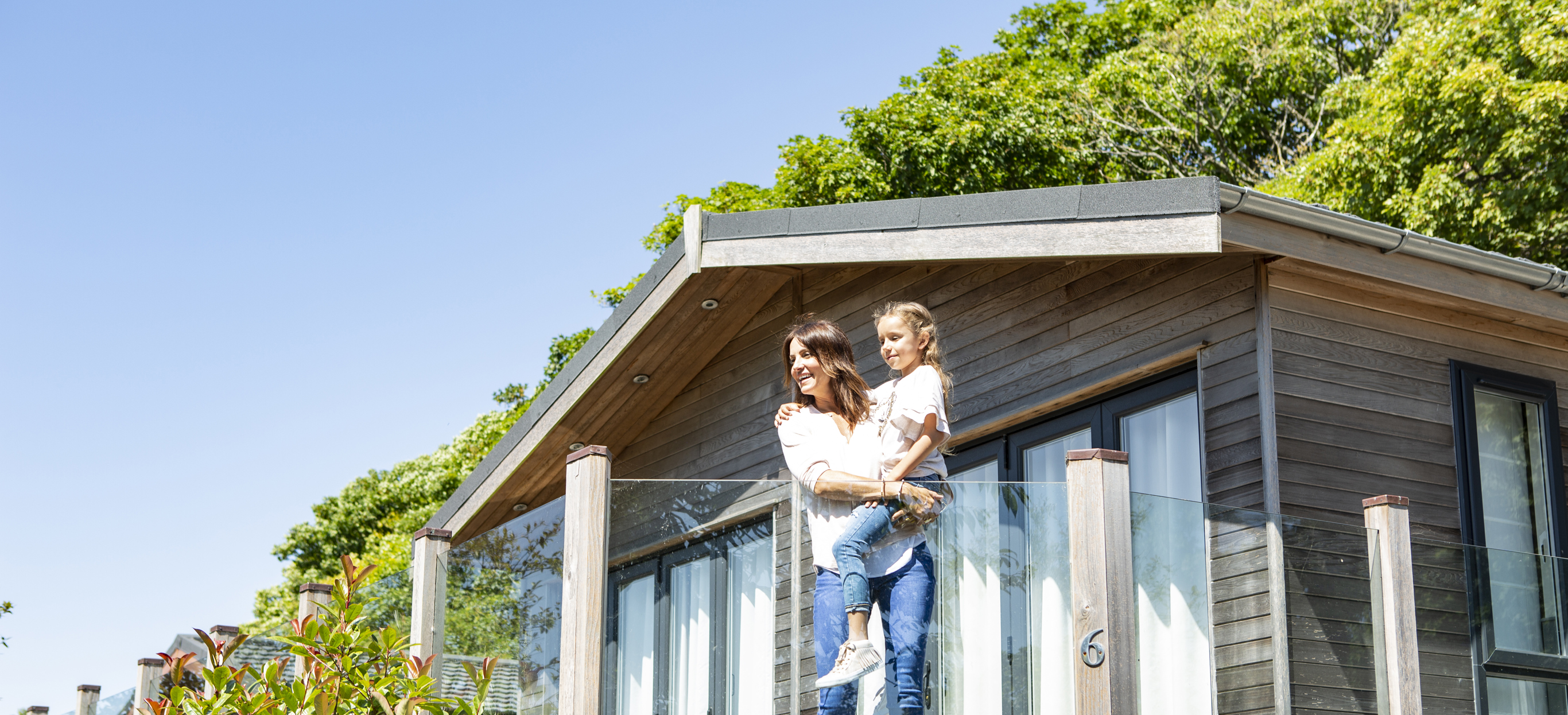mother and daughter enjoy the view from their holiday lodge