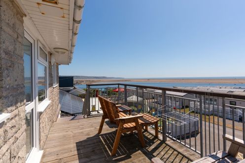 Views of Chesil Beach and the Jurassic Coast from the balcony of Chesil Beach apartments with outdoor furniture