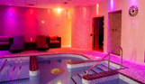 A hydrotherapy pool with loungers and calm lights