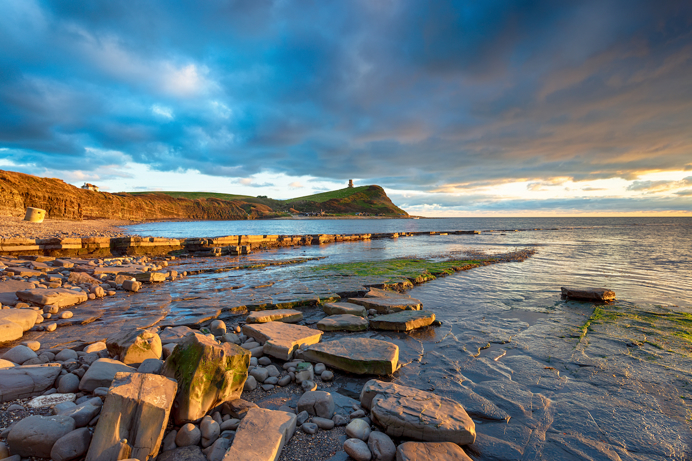 A rocky bay with shallow waters and grassy hills