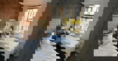 Twin room with wooden panelling and muted tone decor