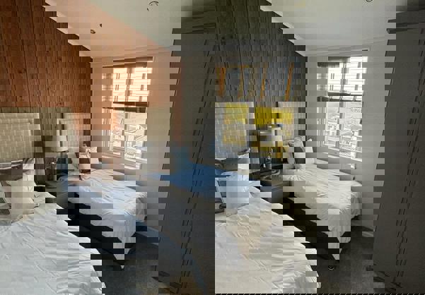 Twin room with wooden panelling and muted tone decor