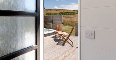 External of a cabin with decking, hot tub and outdoor furniture