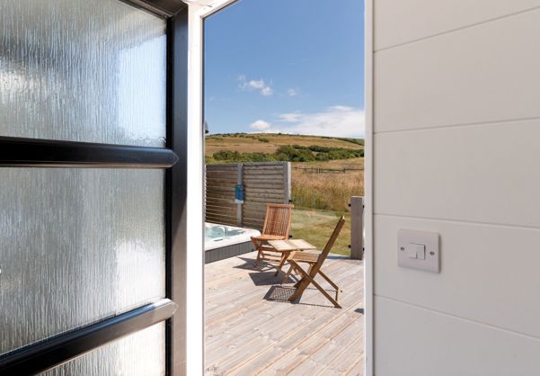 External of a cabin with decking, hot tub and outdoor furniture