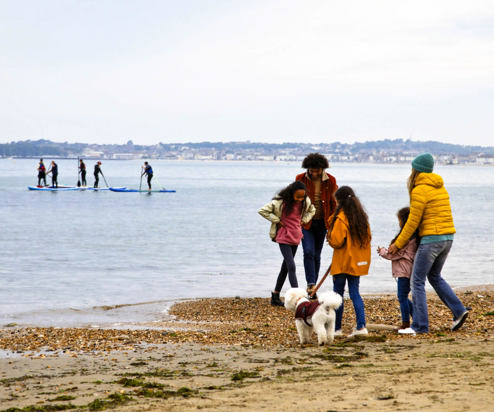 A family of five on the beach with a dog in the colder months