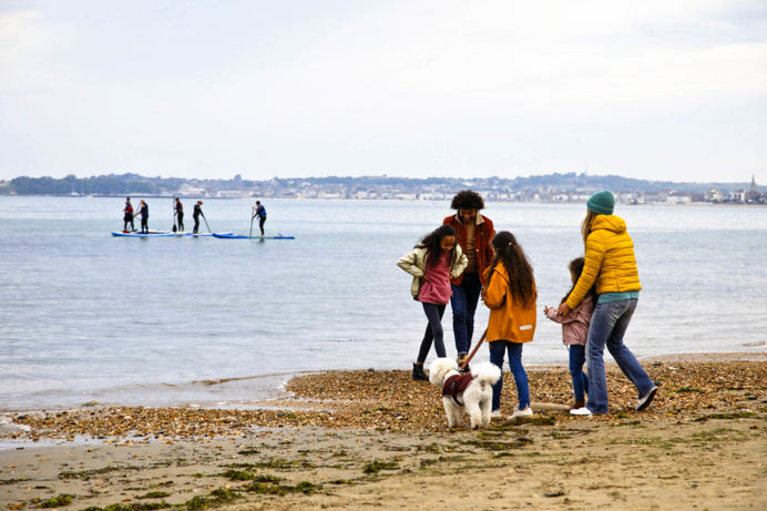 A family of five on the beach with a dog in the colder months