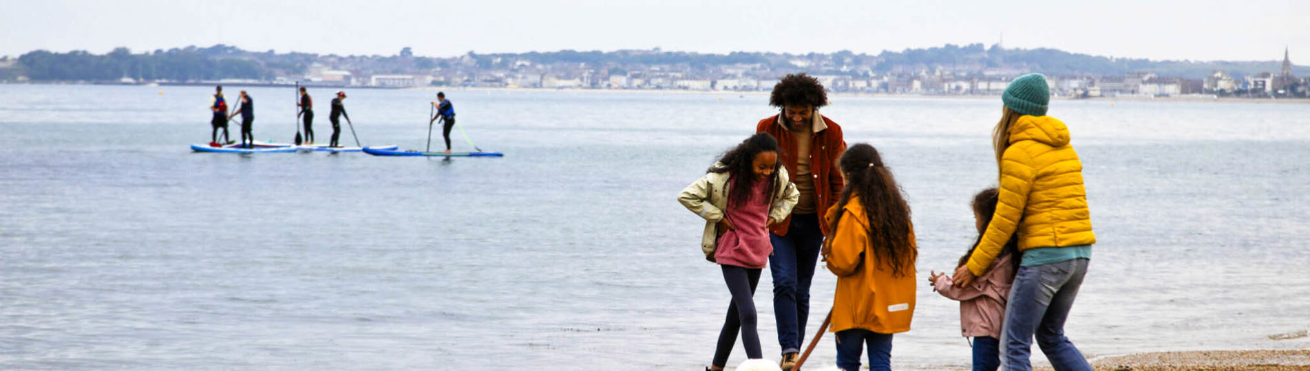 A family of five on the beach with a dog in the colder months