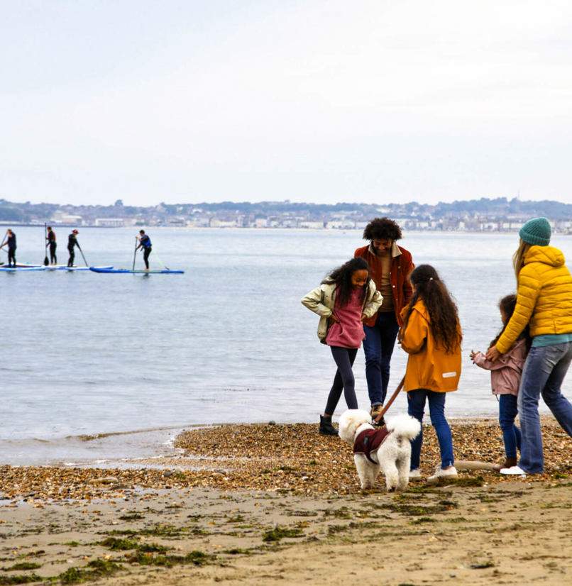 A family of five on the beach with a dog in the colder months