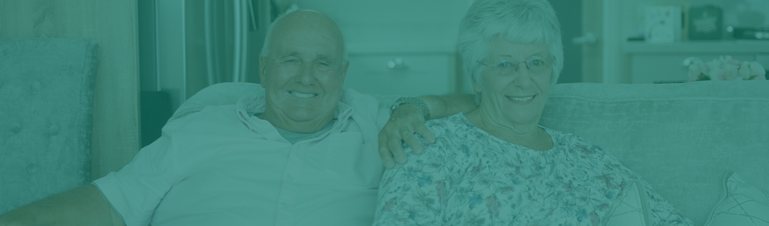 An older couple sat together on a sofa in a holiday home