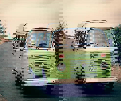 A classic VW old green campervan on the road