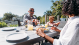 Family sharing a meal on their deck in the sunshine