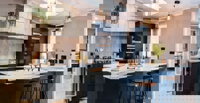 Modern kitchen with large breakfast table and stools in dark blue and light wood design