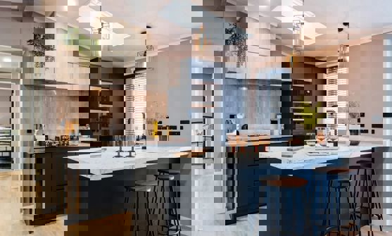 Modern kitchen with large breakfast table and stools in dark blue and light wood design