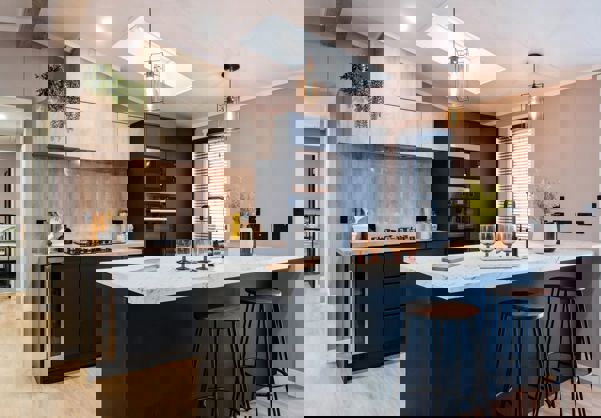 Modern kitchen with large breakfast table and stools in dark blue and light wood design