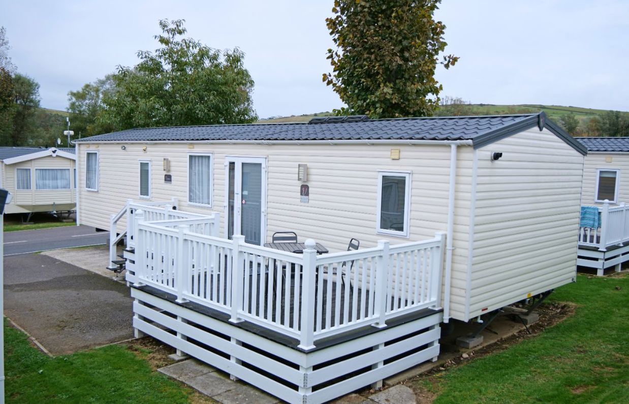 External of a caravan on pitch with decking and outdoor furniture